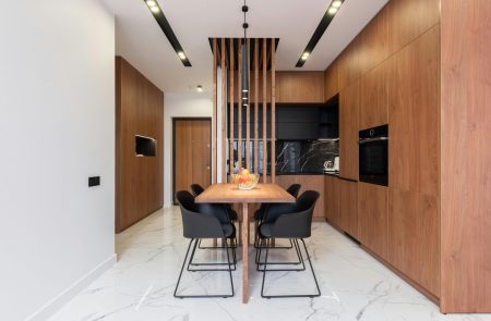 Spacious and stylish kitchen interior with wooden cabinets and dining area.